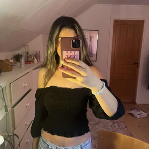 Trendig Svart topp  - Säljer denna superfina svarta toppen från Lindex. Den kan användas som både offshoulder eller som på den sista bilden.  Helt oanvänd, pris kan diskuteras!