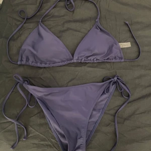Mörkblå triangel bikini - Läs bio! Mörkblå triangel bikini med snörning. Testad 1 gång men var fel storlek. Uttagbar vaddering i kuporna 80% polyamid och 20% Elastan.  Märke: Inte säker men tror TEMU.  Storlek underdel: M storlek överdel: M
