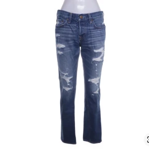 Blå slitna jeansbyxor - Säljer ett par blå jeansbyxor med slitningar och raka ben/bootcut. I nyskick hör av dig vid frågor/bilder. Från hollister❤️