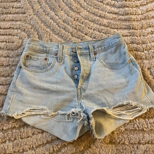 Ljusblå jeansshorts från Levi's - Jag säljer dessa levis shorts då de tyvärr blivit för små. Storleken är 27 och shortsen är i väldigt fint skick. Modellen heter 501 och nypris ligger runt 600 kr. Jag är öppen för att diskutera om priset💓💓
