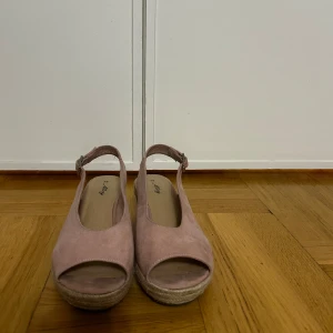 Sandaletter - Säljer ett par ljusrosa sandaletter från Alley med öppen tå. Skorna har justerbart spänne runt ankeln. Perfekta för sommaren!