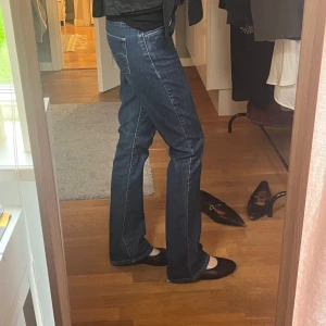 Blå bootcut lågmidjade jeans från Levi's - Klassiska blå jeans från Levi's med bootcut-passform och låg midja. Jeansen har fem fickor, synliga sömmar och Levi's ikoniska bakficka med logotyp. Perfekta till vardags för en avslappnad stil. Midjemått:35 cm innerbenslängd: 78 cm