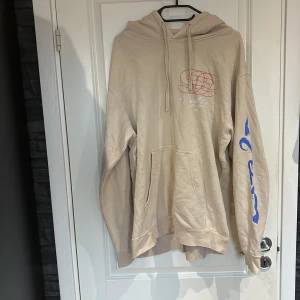 Beige hoodie med tryck från JuiceWRLD - Säljer en beige hoodie från JuiceWRLD. Äkta hoodie men den är dessutom gjort fel på ena armen. Säljs för 150