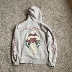 Grå hoodie med tryck från Ed Hardy  - Säljer en grå hoodie från Ed Hardy, knappt använd därav säljs. Står xs men passar s eller stor xs.