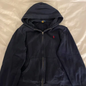 Mörkblå hoodie från Ralph Lauren - En mörkblå Ralph Lauren Hoodie som är väldigt skön och i väldigt bra skick. Storlek är XL i barnstorlek, men den sitter som en vanlig S i herr storlek. Bara att skriva om de finns några frågor eller funderingar💗