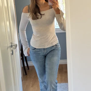 Beige offshoulder topp - Snygg beige offshoulder topp med långa ärmar. Enkel och stilren design som passar till jeans eller kjol. 