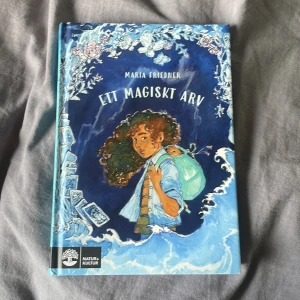 Ett magiskt arv - Ett magiskt arv av Maria Fröjdlier är en ungdomsbok med ett blått omslag och illustration av en tjej med lockigt hår och ett marsvin på axeln. Boken handlar om magiska riter, familjehemligheter och oväntad vänskap.