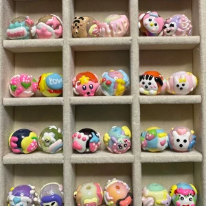 Färgglada handgjorda pärlor med figurer - Unika och färgglada pärlor med olika söta figurer  i pastellfärger. 36 st säljes annars för 6 kr st. Bla kirby, kuromi. Hello Kitty. Perfekt för dig som vill sticka ut med roliga accessoarer! 16 mm