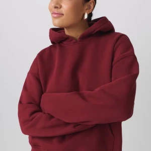 Vinröd hoodie - Säljer en vinröd hoodie med huva och magficka. Tröjan har en avslappnad passform och är perfekt för en chill vardagslook. Mjuk insida och ribbade muddar vid ärmslut och nederkant. Lappen bort klippt men är från Gina 