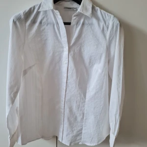 Vit skjorta från Lindex strl 44 - Klassisk vit skjorta från Generous by Lindex. Skjortan har lång ärm, krage och knäppning framtill. Material bomull. Storlek 44. Kan hämtas i Vallentuna.