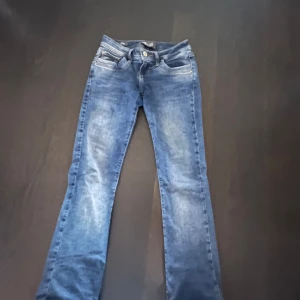 Blå jeans från LTB - Säljer ett par klassiska blå jeans från LTB med fem fickor och snygga slitningar. Jeansen har normal passform och är utsvängda. Perfekta till vardags och enkla att matcha med olika stilar.