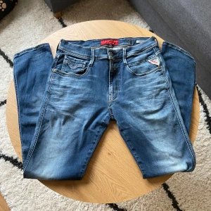 Blå Replay jeans - Hallå👋 Säljer ett par blåa Replay Anbass jeans med snygg slitning och klassisk femficksdesign. Byxorna har normal passform, raka ben och detaljer som läderpatch med Replay-logga bak👖  Perfekta för dig som gillar en tidlös men samtidigt enkel jeanslook🤩  Storleken är W31 L32📐  Priset kan diskuteras vid snabb affär!💸  Vid några frågor: Meddela📩
