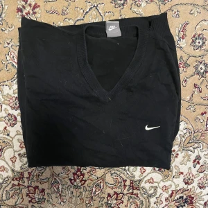 Svart v-ringad tröja från Nike - Säljer en svart v-ringad tröja från Nike med diskret broderad logga på bröstet. Tröjan har långa ärmar och är tillverkad i ett mjukt material som passar perfekt till vardags. Klassisk och stilren design.