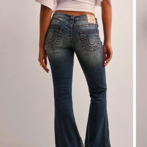 Low waist true religon jeans - Stl 27/32. Använda och slitna längst ner. Har klippt hål på insidan som jag trätt ett snöre igenom. Snyggt helhets intryck