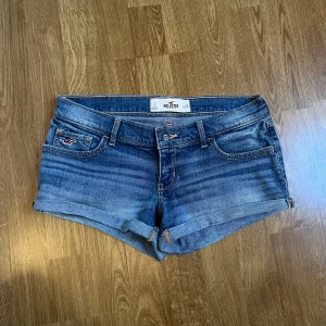 Lågmidjade jeansshorts - Snygga lågmidjade blå jeansshorts från Hollister i storlek w26, mycket fint skick