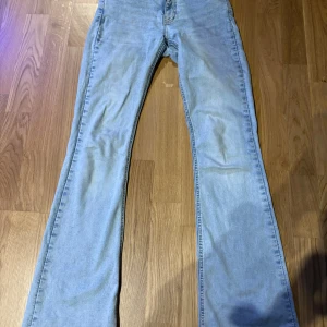 Ljusblå bootcut jeans från Perfect Jeans - Säljer ett par ljusblå bootcut jeans från Gina tricot. Jeansen har klassisk femficksdesign, normal passform upptill och utsvängda ben. Perfekta för dig som gillar retrostil och vill ha ett par bekväma jeans med snygg siluett.