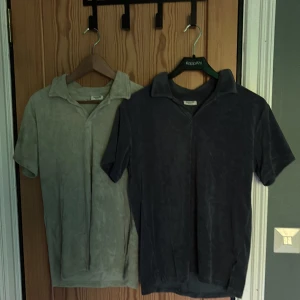 Två frotté pikétröjor från Kappahl - Säljer två pikétröjor från Kappahl i storlek 158/164. Den ena är ljusgrön och den andra är mörkblå. Perfekta för chill dagar eller när du vill ha en avslappnad men snygg look. Endast använda några fåtal gånger.