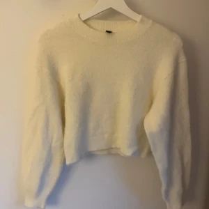 Vit fluffig stickad tröja H&M XS - Supermjuk och fluffig vit stickad tröja från H&M i storlek XS. Tröjan har rund halsringning, lång ärm och en lite croppad passform. Perfekt för lager-på-lager och att mysa i under kyliga dagar.