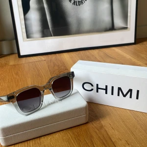 CHIMI 04 i färgen grey  - Snygga solglasögon från CHIMI i modell 04. Säljer pågrund av att har skaffat ett par nya. Köpte som man ser på kvittot från NK för HELA 1200 kr och är i samma skick som nya. Rektangulär form med stilren vibe, perfekt för dig som vill sticka ut med en clean look. Kommer med case och original box och även med kvitto. Kan även gå ner i pris vid snabbt o smidigt köp