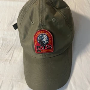 Parajumpers keps - Avtagbart märke med kardborreband. Skick enligt bilderna.