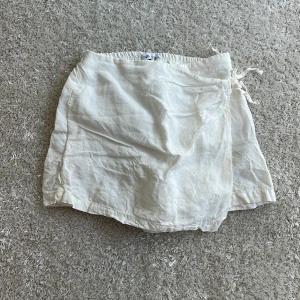 Vita byxkjol i linne med knyt från Zara - Snygga och luftiga vita shorts/kjol från Zara i linne med elastisk midja och knyt i sidan. Perfekta för varma dagar och ger en chill vibe. Passformen är normal och materialet känns svalt och skönt mot huden. Säljer då den är för liten för mig🤗