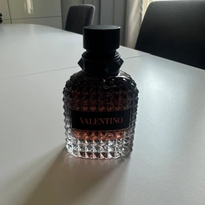 Valentino parfym - Valentino EDT 50ml                                             Lyxig parfym från Valentino i en tung, genomskinlig glasflaska med nitar och diamantmönster. Flaskan har en svart etikett med röd text och svart kork. Doften har en elegant vibe och flaskan är riktigt snygg att ha framme.
