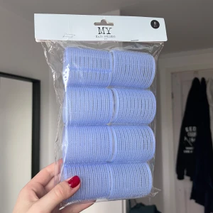 Ljuslila hårrollers 8-pack - Säljer ett 8-pack ljuslila hårrollers, perfekta för att skapa volym och lockar. Rollersen är gjorda i plast med kardborre för enkel användning och har en diameter på 5 cm. Kommer i originalförpackning och är smidiga att använda för styling. Säljer pga att de är för stora för mitt hår. Endast en har varit använd!
