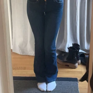 Mörkblå bootcut jeans från ONLY - Säljer ett par mörkblå bootcut jeans från ONLY i storlek S/34. Jeansen har klassisk femficksdesign, medelhög midja och snyggt utsvängda ben. Materialet är stretchigt jeans för en bekväm passform. Perfekta för dig som gillar en tidlös och trendig look.