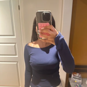 Mörkblå långärmad topp  - Säljer en mörkblå långärmad topp den är rak fram till och har slits på ärmarna. Den är i ett jätte mjukt och skönt material och är stretchig. Den har använts ett par gånger men det syns inte på den.