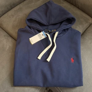 Marinblå hoodie från Ralph Lauren - Säljer en snygg marinblå hoodie från Ralph lauren. Den är i storlek S och i väldigt bra skick. Meddela gärna om du är intresserad.