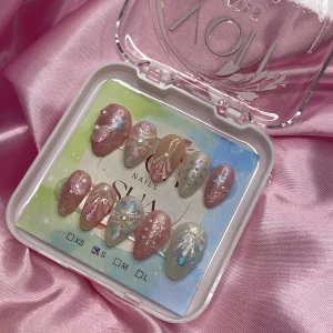 SugarShell (S);Short Almond; Curved - Superfina mermaid gelé press on-naglar i storlek S: 15 mm, 11,5 mm, 12 mm, 11 mm, 9 mm , med rosa, nude och glittriga cateye nyanser. Dekorerade med pärlor, 3D-effekter, glitter, stjärnor och skimrande detaljer. Perfekt för dig som vill ha unika och glamorösa naglar utan att gå till salong.