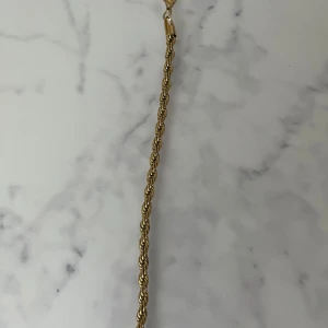 Guldigt armband med tvinnad kedja - Snyggt armband i guldig färg med tvinnad kedja som ger en cool och trendig look. Perfekt accessoar för att lyfta din outfit. Lätt att matcha med andra smycken och har ett smidigt lås. Finns 9 stycken kvar vill ni ha fler så är de ba att skriva så löser jag 