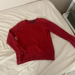 Röd tröja Polo Ralph Lauren - Säljer en röd stickad tröja från Polo Ralph Lauren. Tröjan är liten i storlek N för jag som är xs kan ha på mig den utan att den är för stor. Nypris: över 1000 Tröjan har rund halsringning, långa ärmar och den klassiska lilla broderade loggan på bröstet. Perfekt för dig som gillar en tidlös och snygg look.