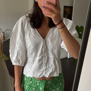 Vit blus HM - Superfin vit blus i linne med v-ringning, puffiga trekvartsärmar och knäppning framtill. Har sytt till en knapp då jag tyckte att den var lite väl djup i ringningen men går att sprätta upp🌷 poppis topp från H&M