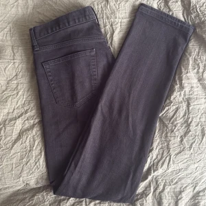 Svarta jeansbyxor från Uniqlo - Säljer ett par svarta jeansbyxor från Uniqlo. Klassisk femficksmodell med dragkedja och knapp i midjan. Byxorna har raka ben och normal passform, perfekta till många olika outfits. Strl 12 enligt etikett. 