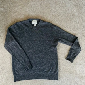 Mörkgrå tröja från H&M Edition 100% kashmir  - Säljer en stilren mörkgrå tröja från H&M Edition. Tröjan har rund halsringning och är tillverkad i mjukt material med ribbade muddar vid ärmslut och nederkant. Perfekt för lager-på-lager under kyliga dagar. 100% cashmere