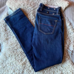 Tramarossa Leonardo Jeans - Säljer dessa galet snygga mörkblå jeans i den eftertraktade modellen Leonardo från Tramarossa med klassisk femficksdesign och kontrastsömmar. Byxorna har en riktigt trevlig slim passform, samt silverfärgad knapp och dragkedja. Tramarossa tillverkas i Italien, Veneta. Perfekta till vardags och enkla att matcha med olika stilar. Byxorna har inga större täcken på användning och befinner sig i skick 9/10. Nypris ca 4000 kronor. Tveka inte på att höra av dig vid frågor eller funderingar!
