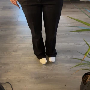 Svarta kostymbyxor med bootcut - Snygga svarta kostymbyxor med bootcut passform och klassiska fickor bak. Byxorna har hällor för bälte och stängs med dragkedja. Perfekta för en stilren look och passar till många olika outfits. Kostymbyxorna har använts fåtal gånger och är i stolek medium. Nypris på byxorna var 499kr. 🤍🥂