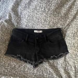 Svarta jeansshorts från Hollister - Snygga svarta jeansshorts från Hollister med fransig kant nertill och låg midja. Waist 25 så skulle säga att de passar en xs, själv har jag midjemått 80 och de är lite små men funkar