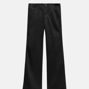 Svarta vida byxor från Zara - Säljer ett par svarta byxor från Zara med vid passform och klassisk femficksdesign. Byxorna har medelhög/låg midja och raka, vida ben som ger en trendig siluett. Aldrig använda med lapp kvar🖤