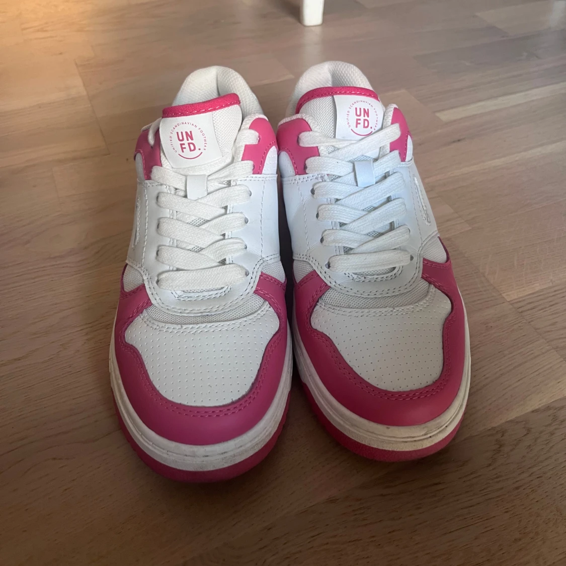 Vita och rosa sneakers från UNFD