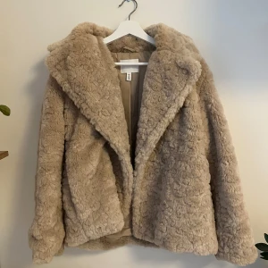 Beige pälsjacka från H&M - Säljer en fluffig och mjuk beige pälsjacka från H&M i storlek S. Som ny, endast använt 2 gånger
