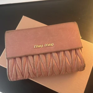Miu miu plånbok - !PRIS KAN DISKUTERAS! Denna är sliten men har fortfarande sin potential. Lådan som jag fick den i får man när man köper(ni fattar). Och plånboken får plats med mycket!💕💕
