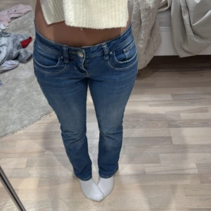 Blå jeansbyxor från LTB - Säljer ett par klassiska blå jeansbyxor från LTB med normal passform och utsvängda  ben. Byxorna har fem fickor, bälteshällor och stängs med dragkedja och knapp. Perfekta till vardags och lätta att matcha med olika toppar.