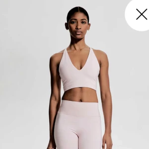 Ljusrosa  träningstopp hm move - Säljer en ljusrosa  träningstopp med smala korsade axelband i ryggen och djup v-ringning fram från hm och helt slutsåld. Perfekt för gym eller yoga. Använd 1 gång🩷