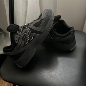 Svarta New Balance sneakers - Säljer ett par svarta New Balance sneakers med grå detaljer och klassisk N-logga på sidan. Skorna har snörning och en robust, bekväm sula. Perfekta för vardagsbruk och streetstyle.