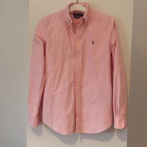 Rosa skjorta från Polo Ralph Lauren - Rosa skjorta från Polo Ralph i storlek S/XS. Perfekt nu till sommaren. Hör av dig vid frågor eller funderingar, pris kan diskuteras vid snabb affär!