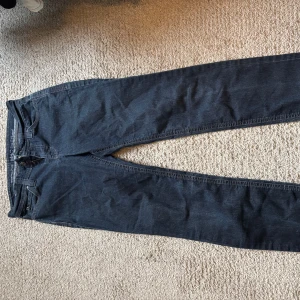 lågmidjade MAC jeans - Säljer ett par klassiska lågmidjade mörkblå jeansbyxor med normal passform och raka ben. Byxorna har dragkedja och knappar i gylfen samt fem fickor. Perfekta till vardags och lätta att matcha med olika outfits.