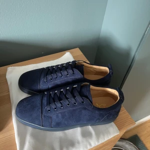Christian Louboutin Skor - Säljer ett par HELT nya mörkblå sneakers från Christian Louboutin med klassisk röd sula. Inga som helst tecken på användning. Priset kan diskuteras vid snabb affär.