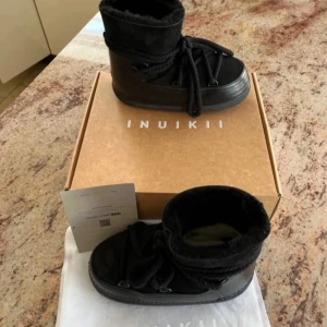 Svarta boots från Inuikii - Säljer ett par svarta boots från Inuikii med tjock sula och snörning framtill. Skorna har en rund tå och är fodrade för extra värme. Perfekta för kyliga dagar och har en stilren design. Jag säljer 2 par en i st 36 och 38 styck pris är 1300 ordinarie pris 3000 kr 